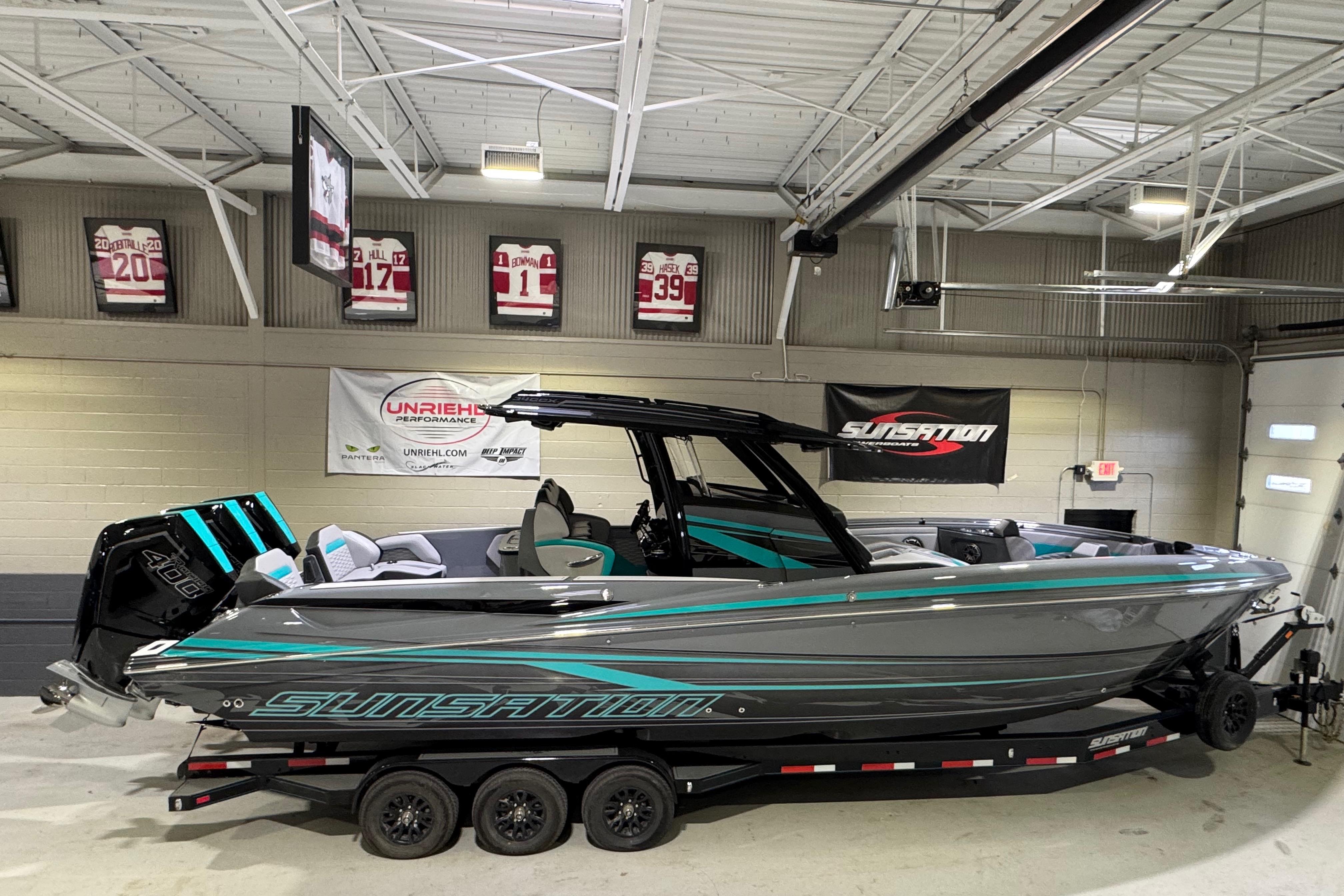 2026 Sunsation 34 CCX boat in showroom, sleek design with vibrant accents.